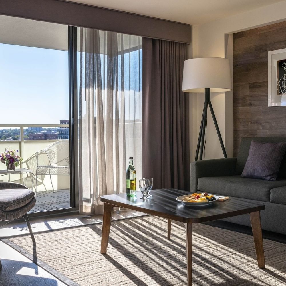 Living area with a sofa by a coffee table under a floor lamp in Premier Junior Suites at Warwick Denver