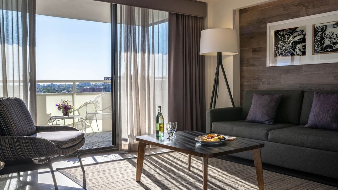 Living area with a sofa by a coffee table under a floor lamp in Premier Junior Suites at Warwick Denver