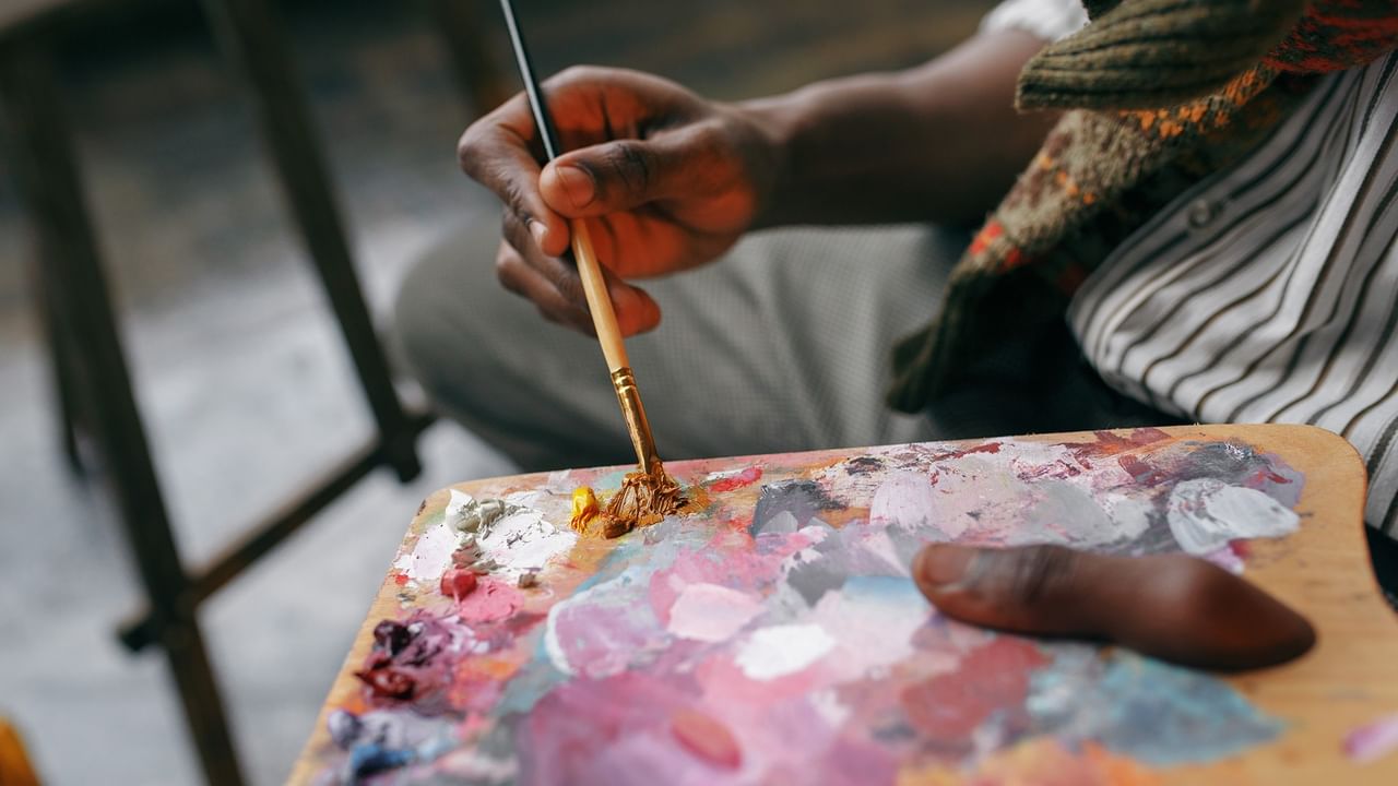 Artist holding a paintbrush and colorful palette