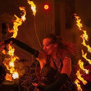 A lady is performing a dance with fire during the penang international food festival.
