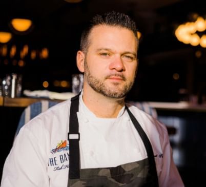 Robert Sisca Smiling in a Chef's Uniform