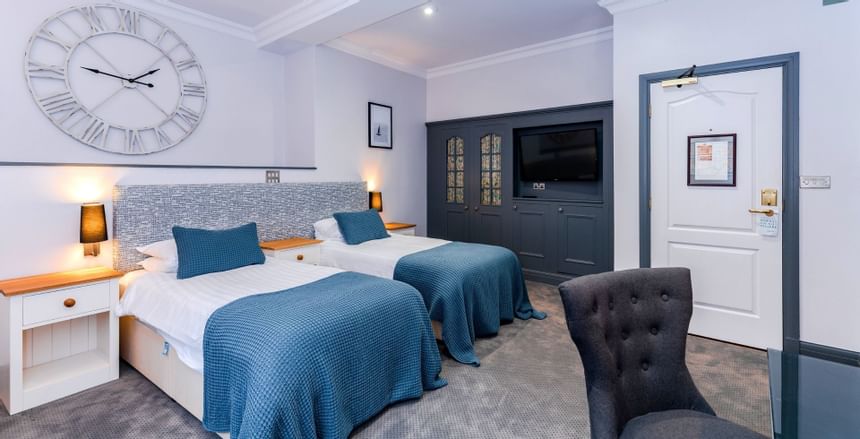 Double bed with large clock in Double room at Villiers Hotel