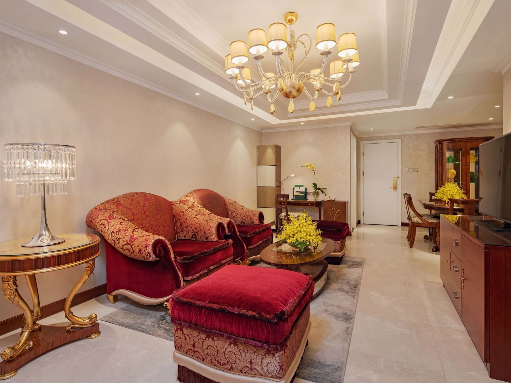 luxurious living room with maroon sofa, coffee table and television