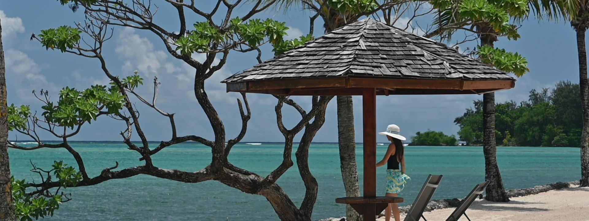 Woman in sunhat at beach cabana with ocean view at Warwick Le Lagon - Vanuatu, Efate