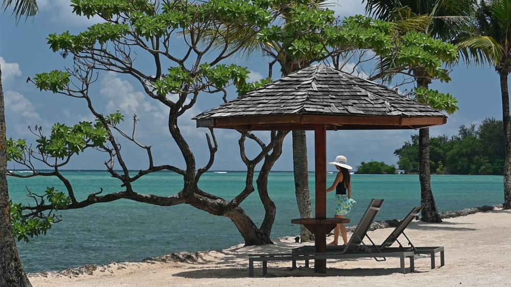 Woman in sunhat at beach cabana with ocean view at Warwick Le Lagon - Vanuatu, Efate.