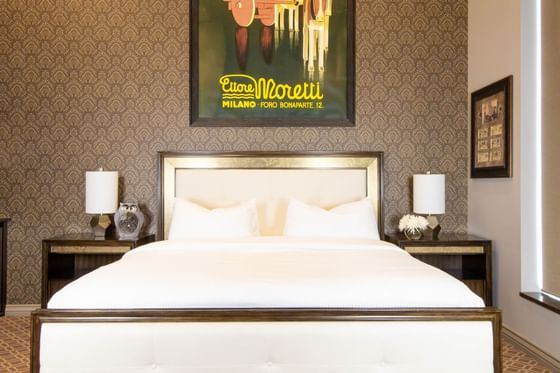 Bed with comfy pillows, bedside tables & lamps in King Premiere Ranch at Retro Suites Hotel