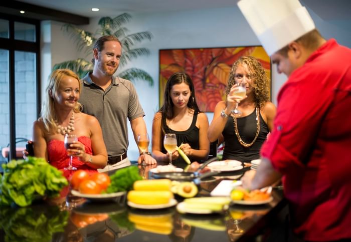 A chef preparing food around with hotel guests at Los Altos Resort