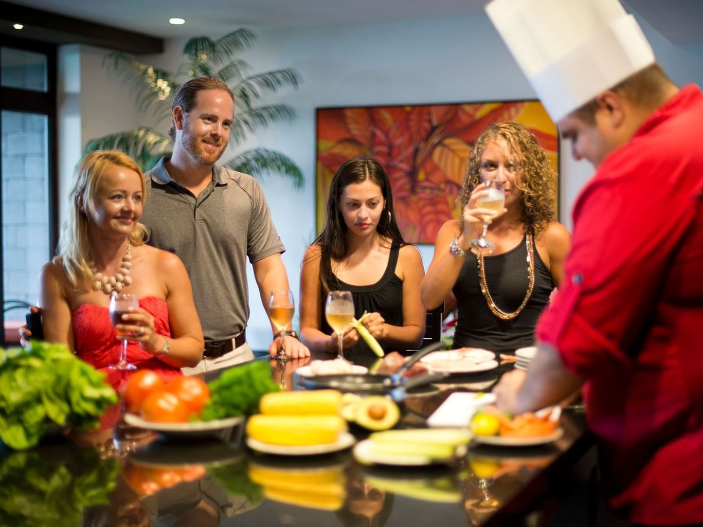 Personas reunidas alrededor de una mesa con una variedad de comida en Los Altos Resort