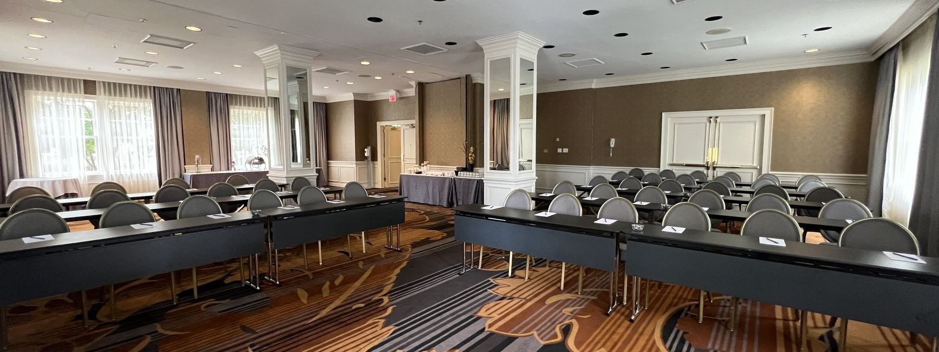 Rows of desks by grey chairs under a high ceiling in Oak Lawn/Terrace at Warwick Melrose Dallas