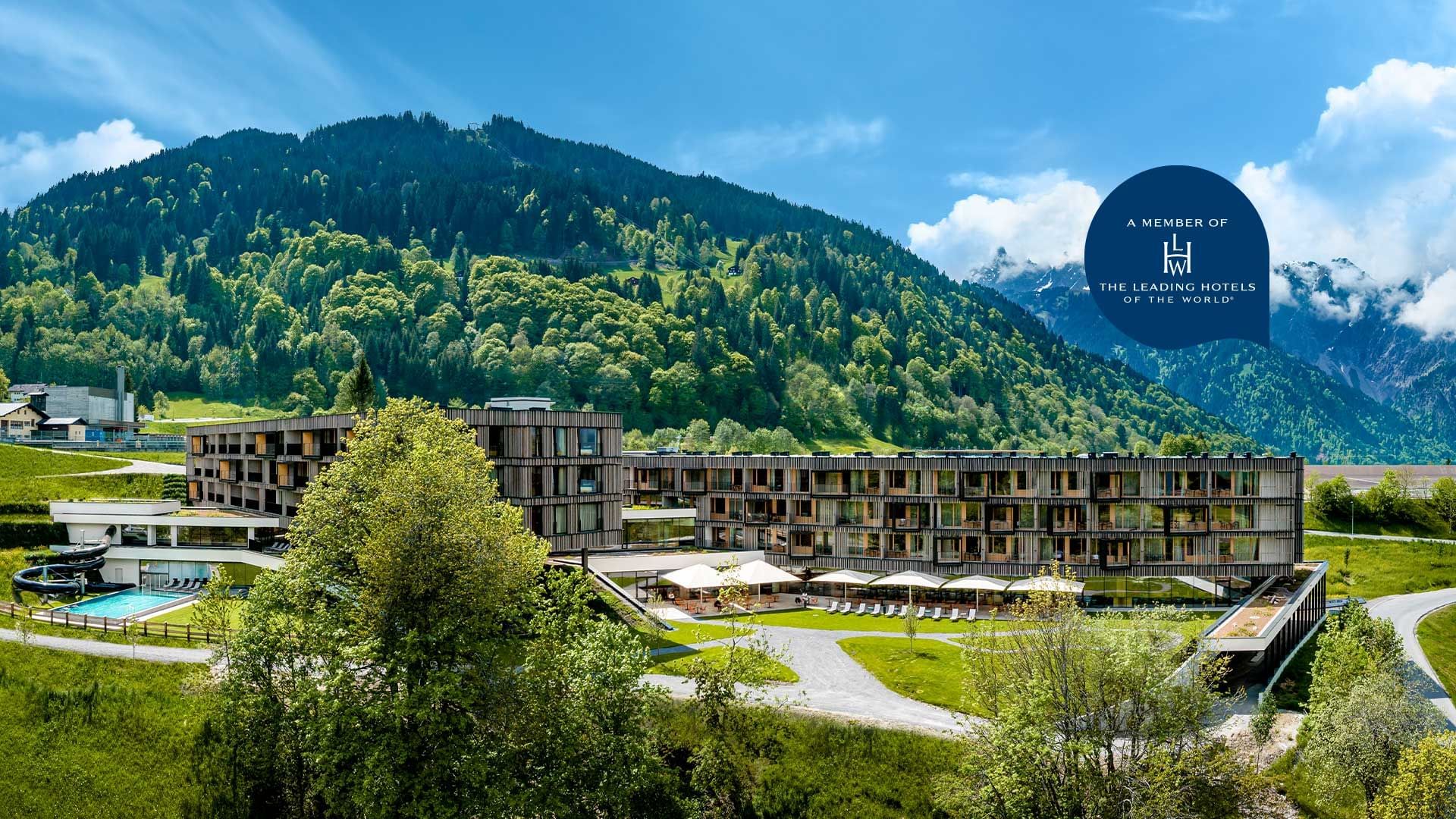 Poster with Falkensteiner Hotel Montafon exterior by forested mountains