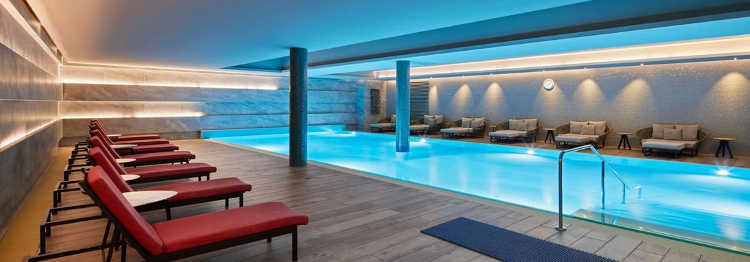 Indoor pool area with lounges at Titanic Chaussee Berlin