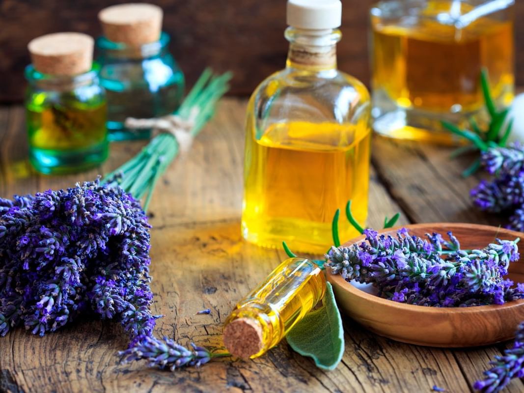 Glass bottles of oil with lavender flowers on a table at Villa Premiere Boutique Hotel & Romantic Getaway