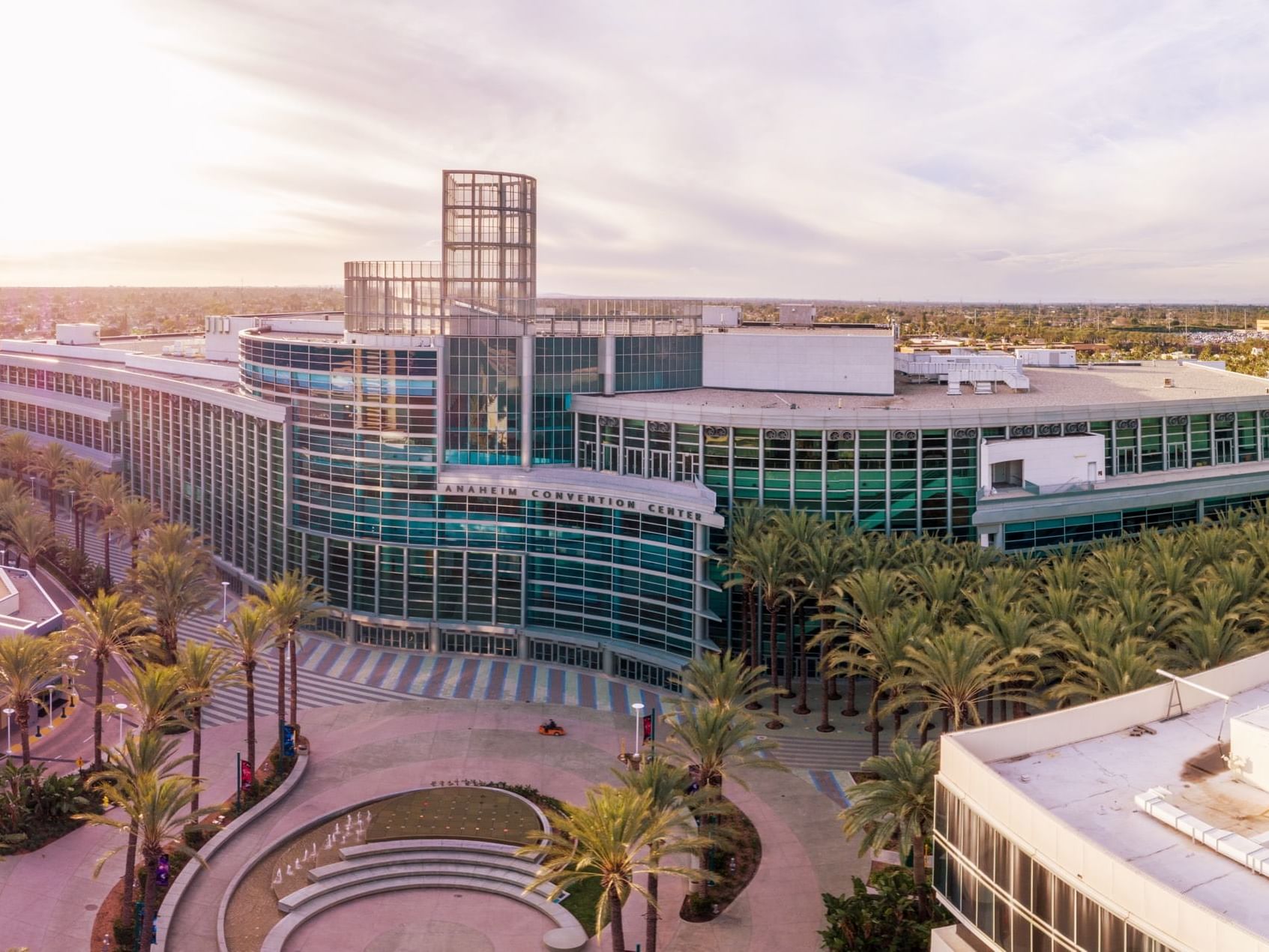 Aerial view of Anaheim Convention Center with modern architecture and palm trees.