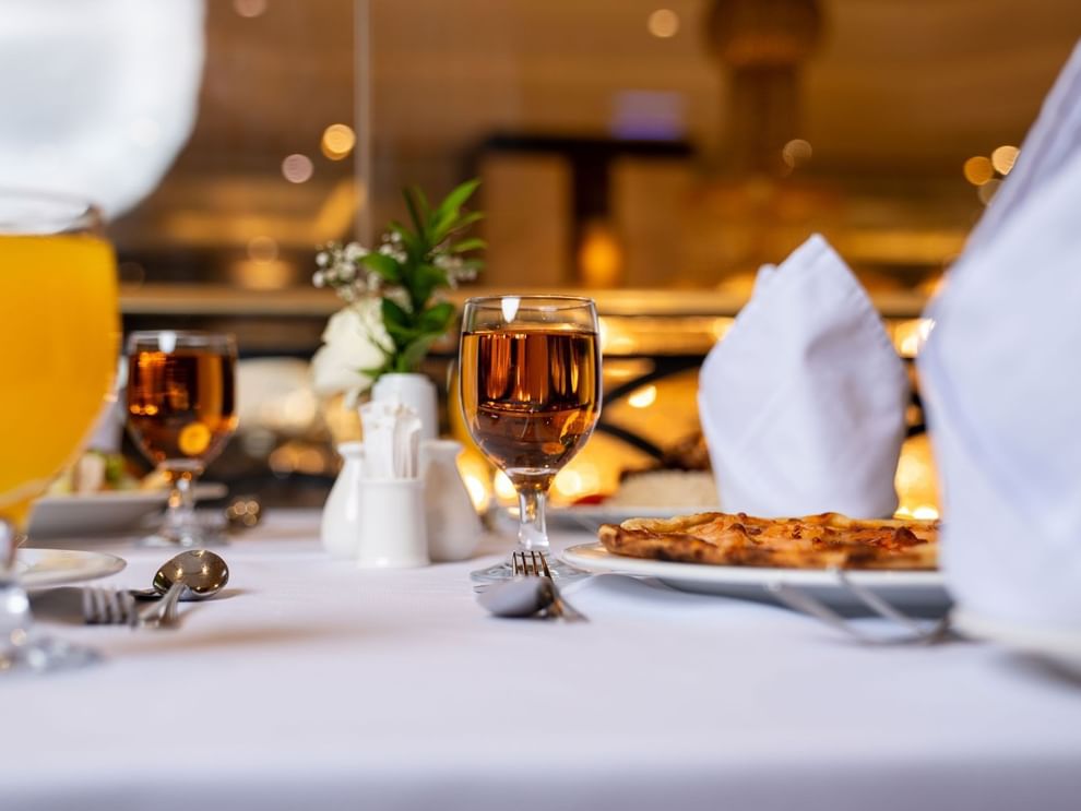 Close-up of a set dining table with glasses of juice and tea in Al Duhaa restaurant at Saja Warwick Madinah