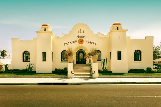 Exterior of Anaheim Packing House with cactus by a stone path under a clear sky near Anaheim Portofino Inn & Suites