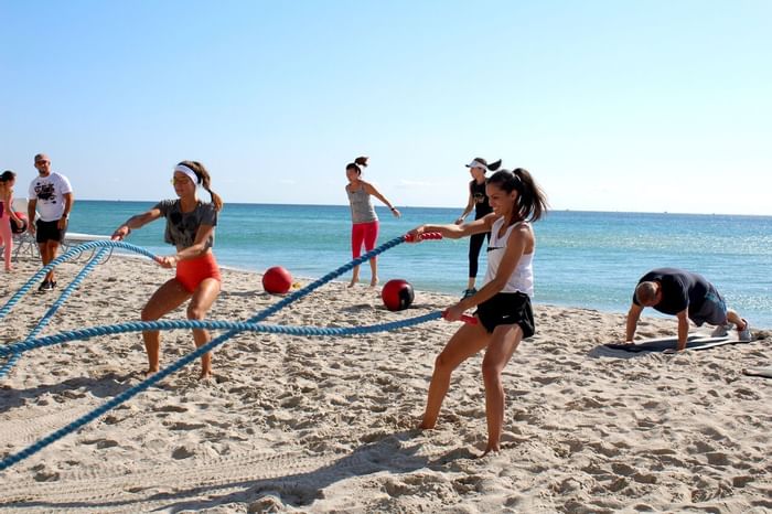 People doing fitness exercises near the beach at Diplomat 
