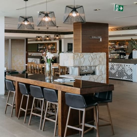 High Table arranged with chairs in Shallows Bar at Pullman Magenta Shores Resort