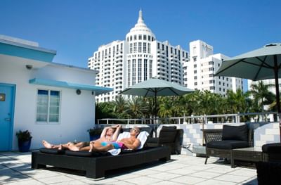 A couple relaxing on sunbeds at the terrace in Aqua Hotel