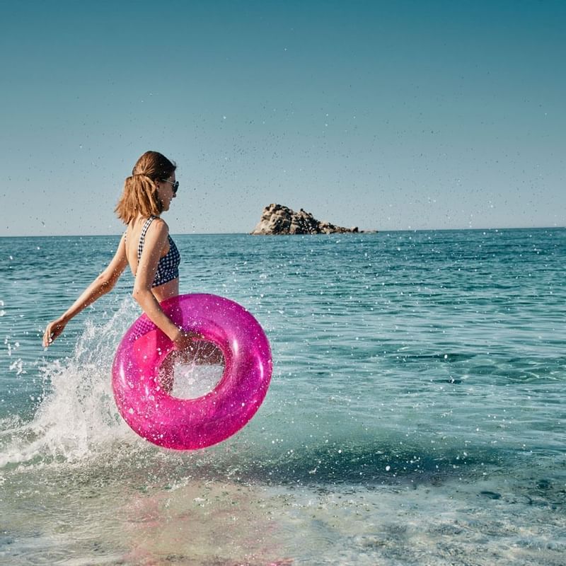 Lady with the pink float in the sea near Falkensteiner Hotels
