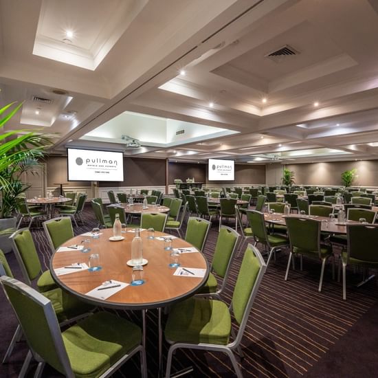Banquet set-up with projector screens in Ibis Room at Pullman Sydney Hyde Park