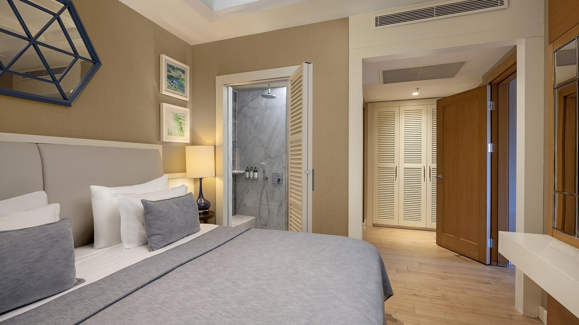 Роскошная спальня в Titanic Luxury Collection Bodrum с большой кроватью, телевизором и зеркалом.