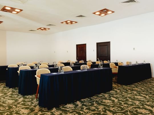 Classroom set-up with water bottles and carpeted floors in Indato II at Camino Real Zaashila Huatulco