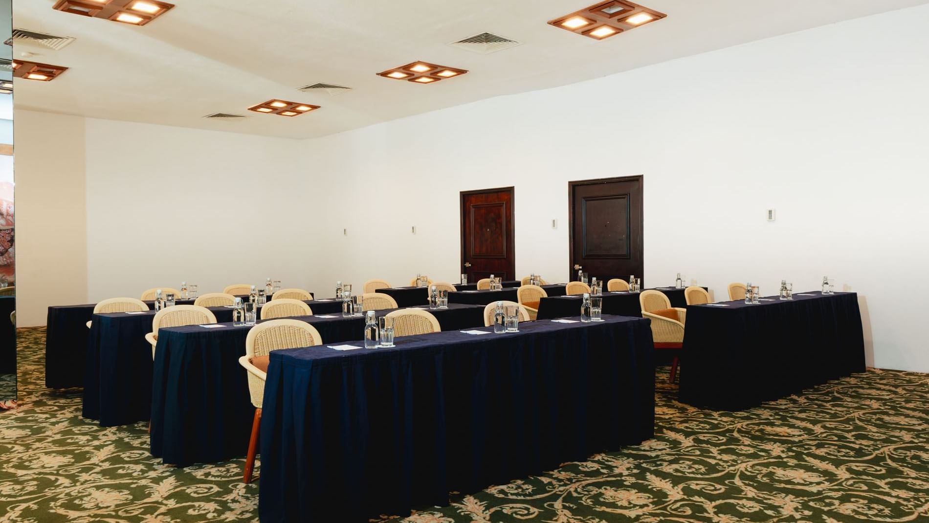 Classroom set-up with water bottles and carpeted floors in Indato II at Camino Real Zaashila Huatulco