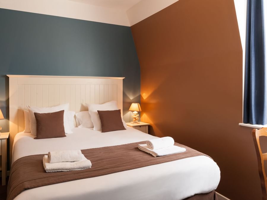 Bed & furniture in a room at Hotel de la Plage
