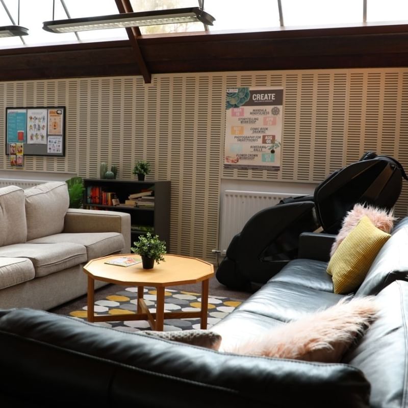 Lounge with couches, coffee table, and posters at La Trobe University - Chisholm College.