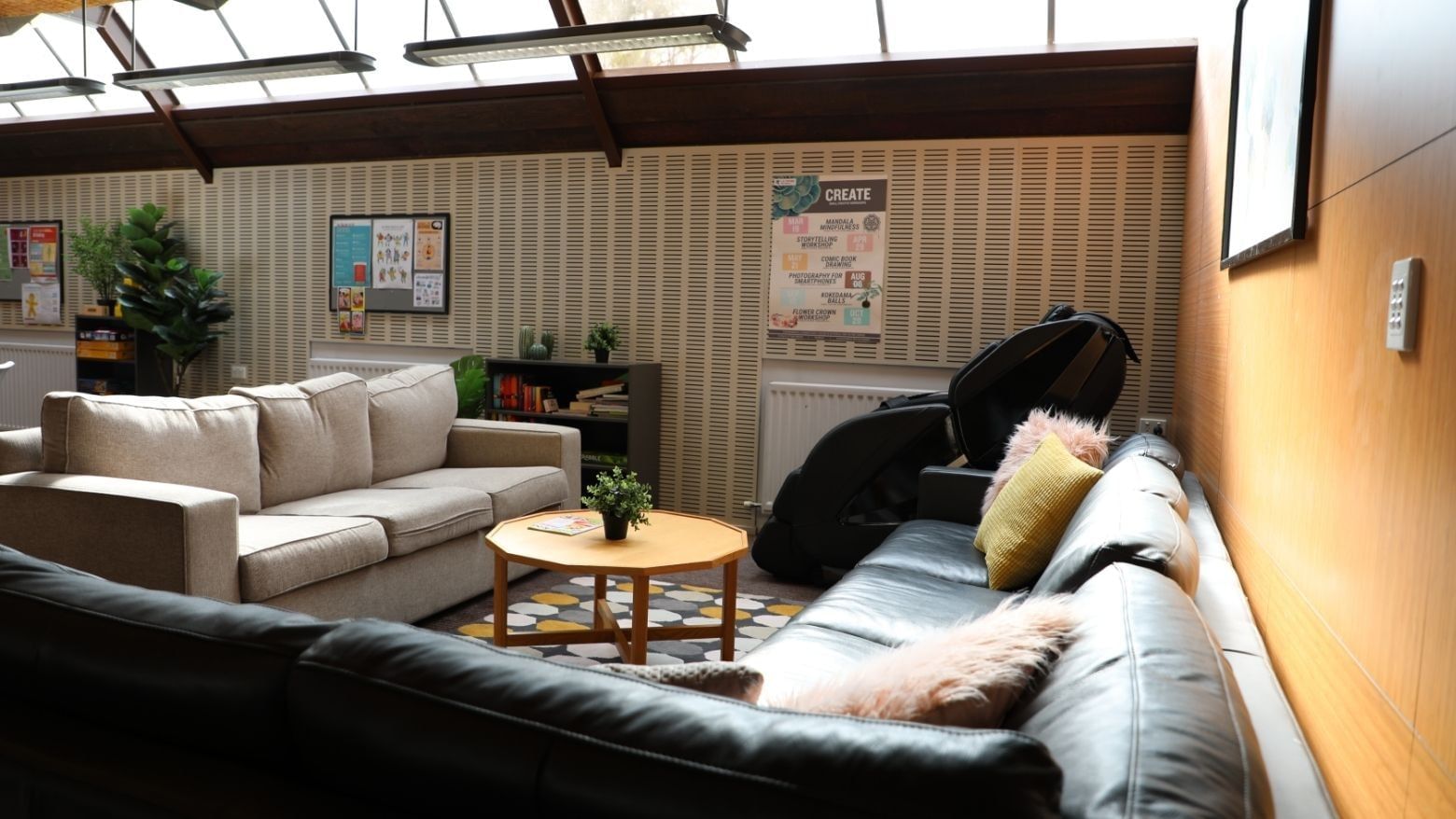 Lounge with couches, coffee table, and posters at La Trobe University - Chisholm College.