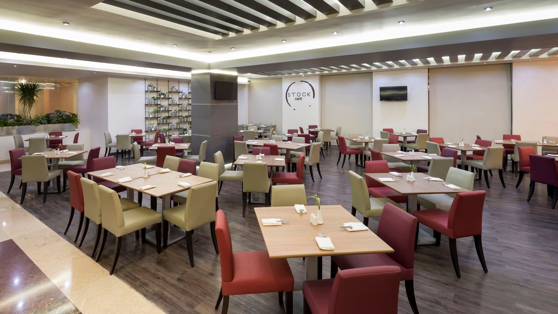 Stock Cafe interior with wooden tables, red and beige chairs at Real Inn San Luis Potosi