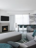 Warwick Premier Suite living area with a sofa facing the TV and fireplace at Warwick Le Crystal Montreal