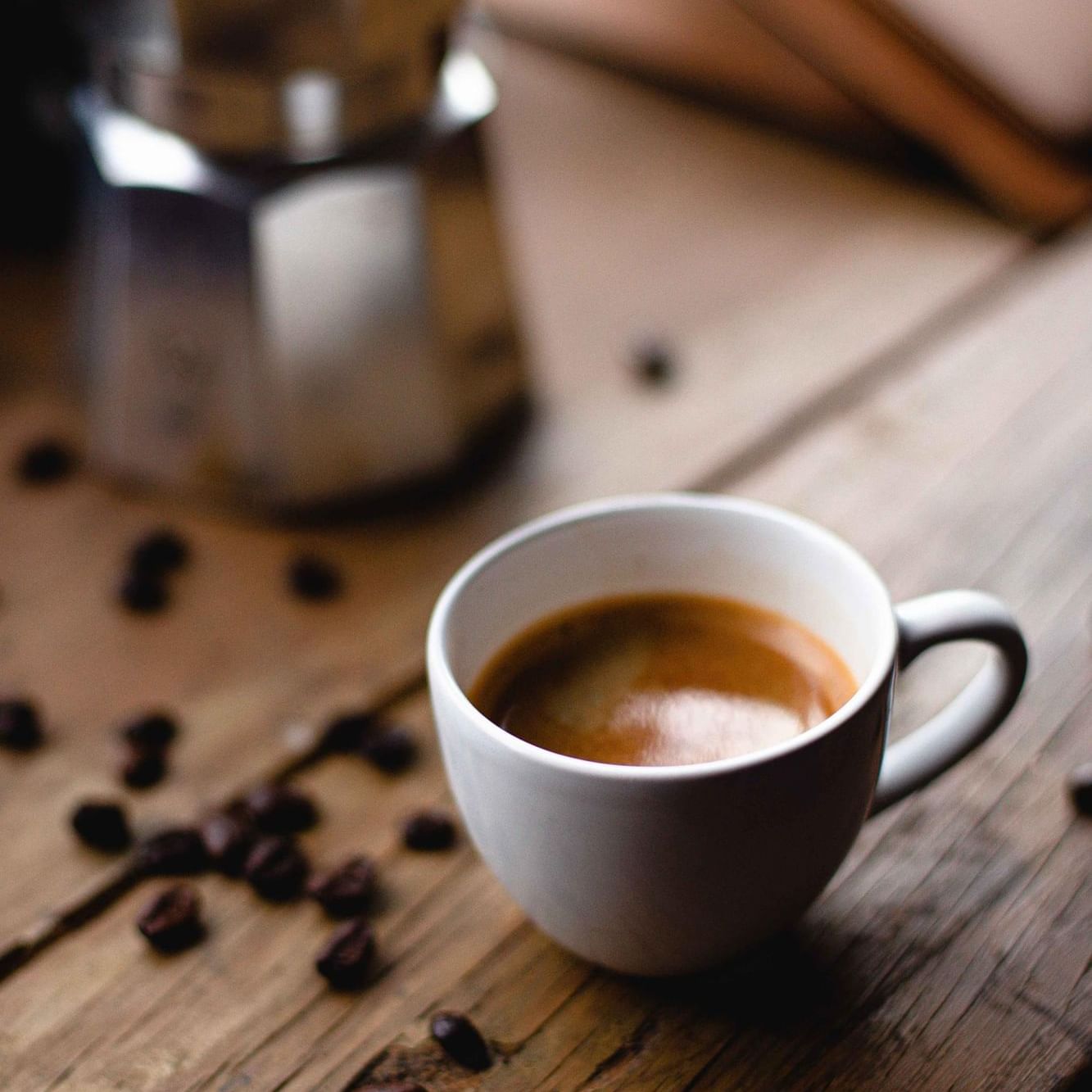 Cup of coffee & coffee beans on a table at The Artisan Hotel at Tuscan Village