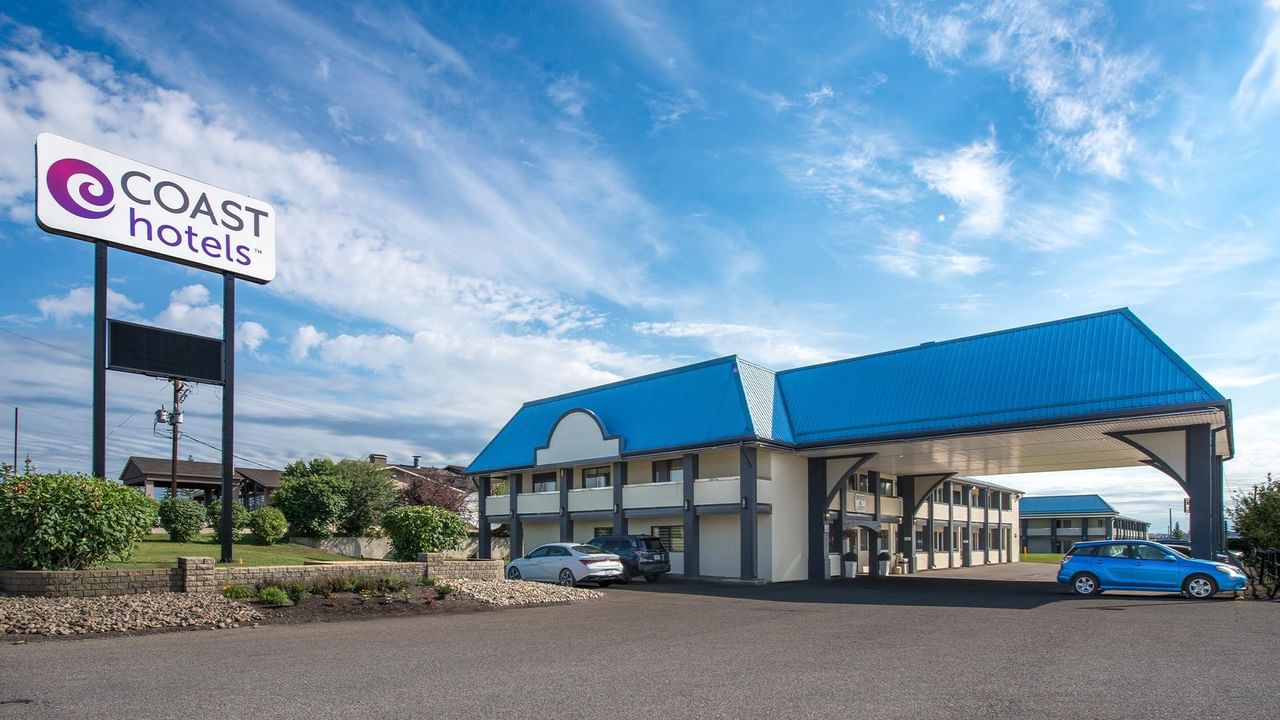 Exterior entrance of Coast Red Deer Hotel with roadside sign