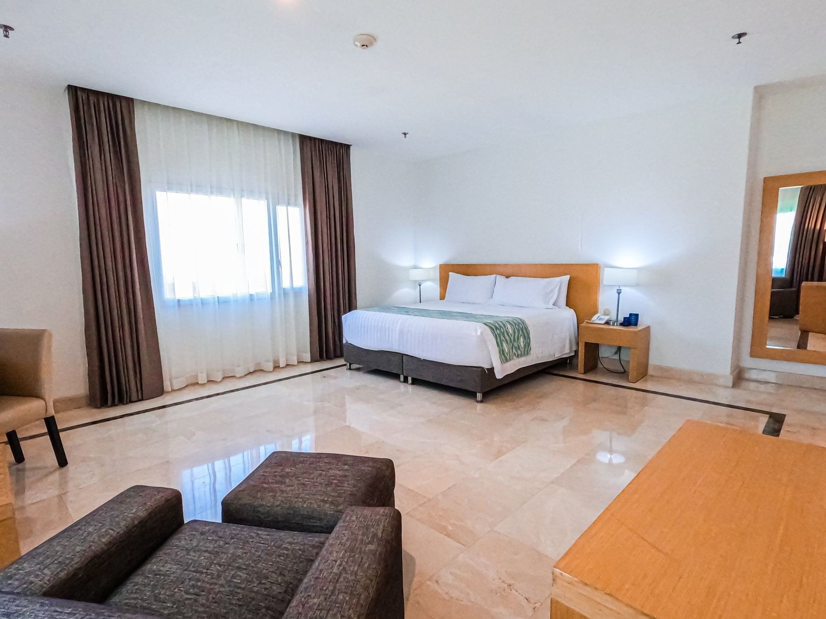 Cozy bed and lounge in Grand Suite King at Hotel Dann Carlton Baranquilla