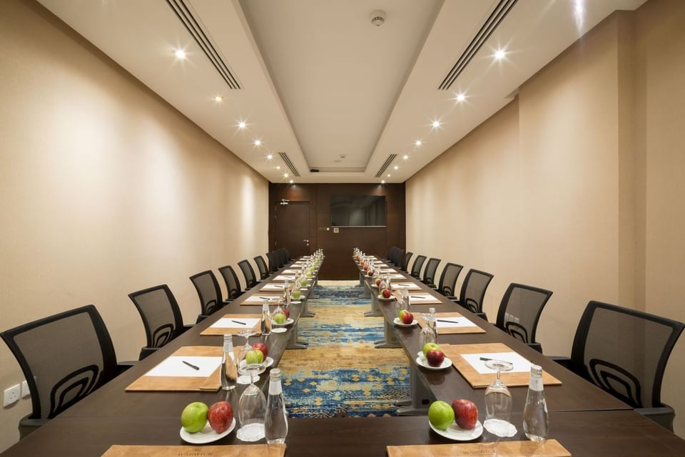 U-shaped table setup facing hanging TV in Khalej Meeting Room at Naviti by Warwick Dammam 