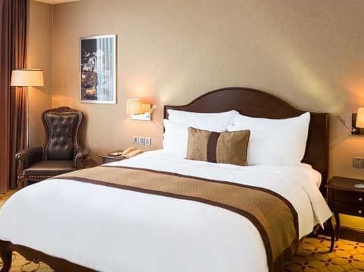 Club Deluxe Room with king bed, lamps & comfy chair at Eastin Grand Hotel Saigon