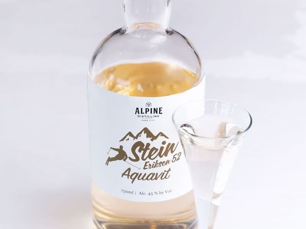 A bottle of Alpine Distilling Aquavit & glass at Stein Lodge