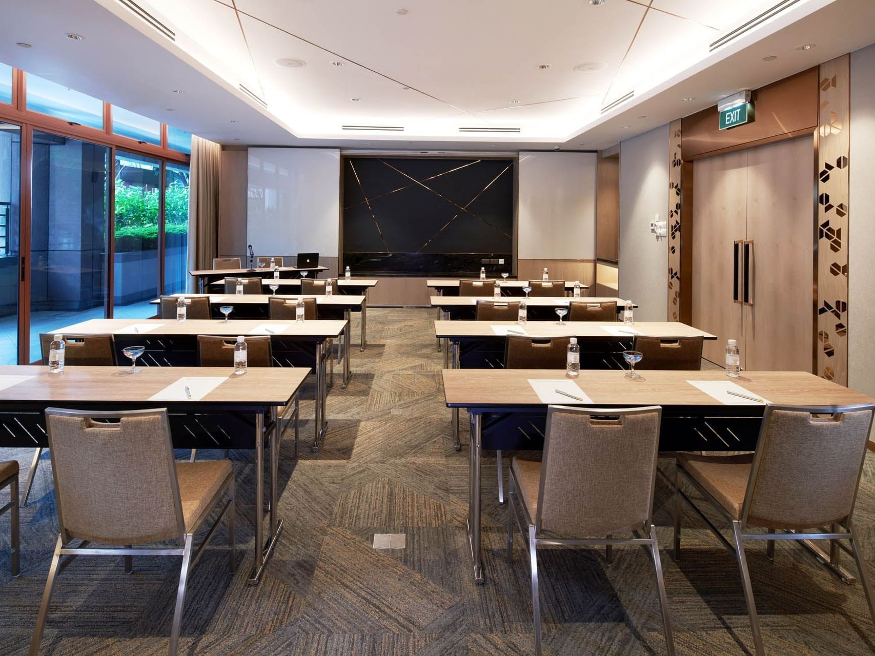 Modern conference room with a classroom table set up and a sleek presentation screen at Orchard Grand Court