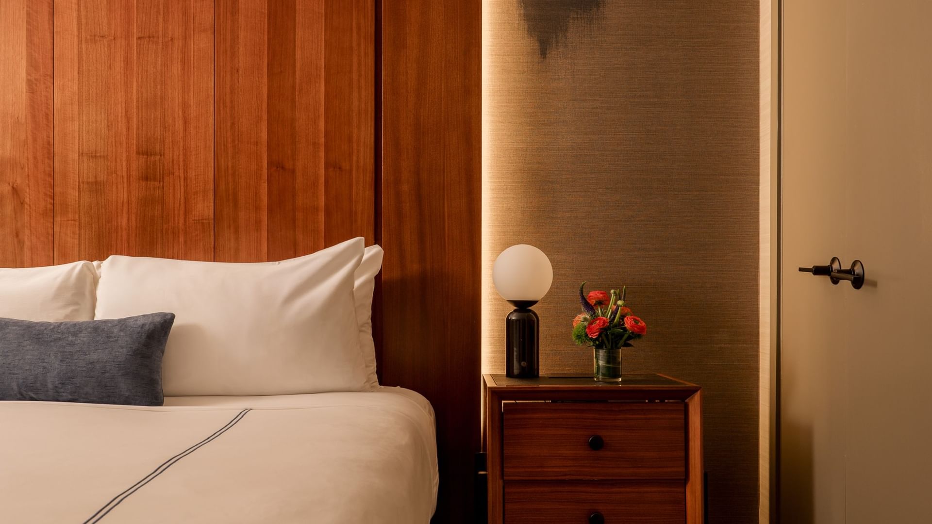 Two-Bedroom Manhattan Suite with wood-paneled wall, white bedding, and modern nightstand at Gansevoort Meatpacking NYC