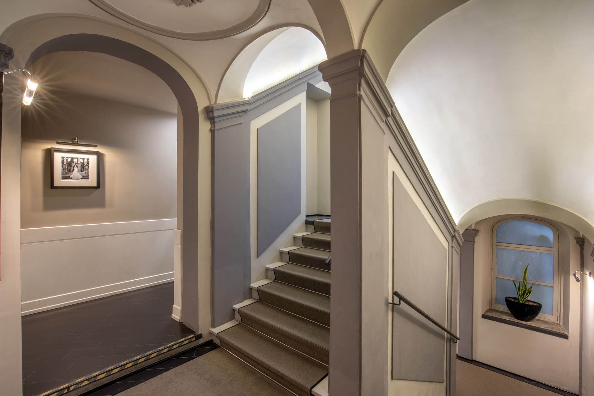 View of a stairway in the lobby with arched walls at The Style