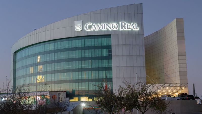 Close-up of the illuminated Camino Real Pachuca hotel sign on the modern white facade in twilight hour