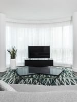 Élégant salon avec canapé, télévision et fauteuil dans la suite Crystal du Warwick Le Crystal