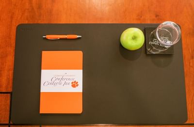 mat with paper, pen, apple and cup