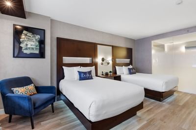 Beds with a side table and hanging wall art in Double Standard Room at The J House Greenwich
