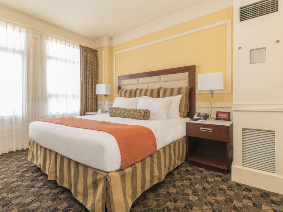 Cozy hotel room with large bed and warm decor at Pickwick San Francisco.