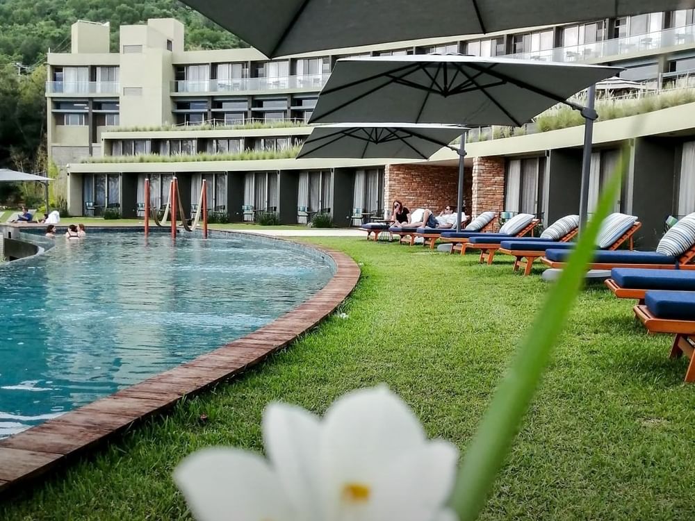 View of Poolside area with sun beds and huts at Gamma Hotels