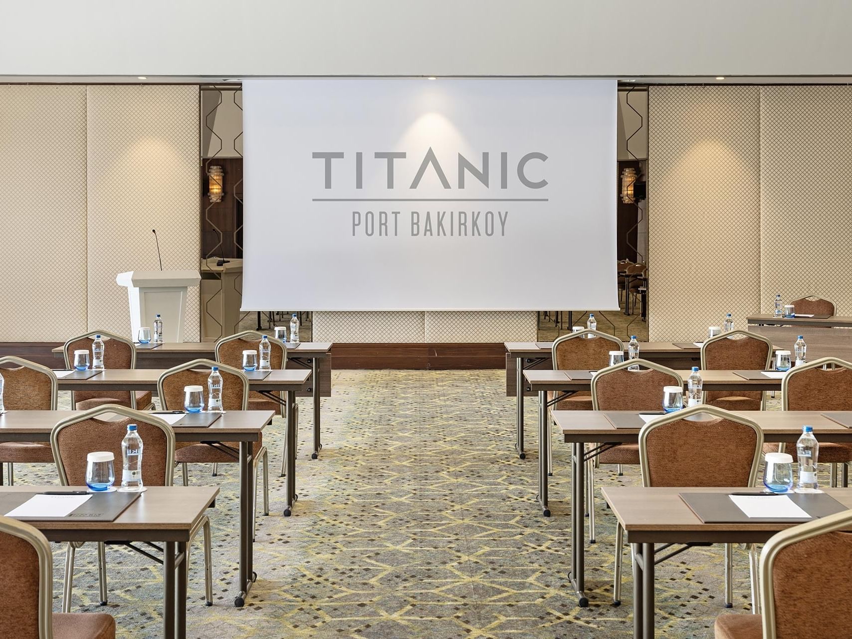 Adriatic toplantı salonunda sınıf düzeninde masa kurulumu, kürsü ve projeksiyon perdesi Titanic Port Bakırköy’de.