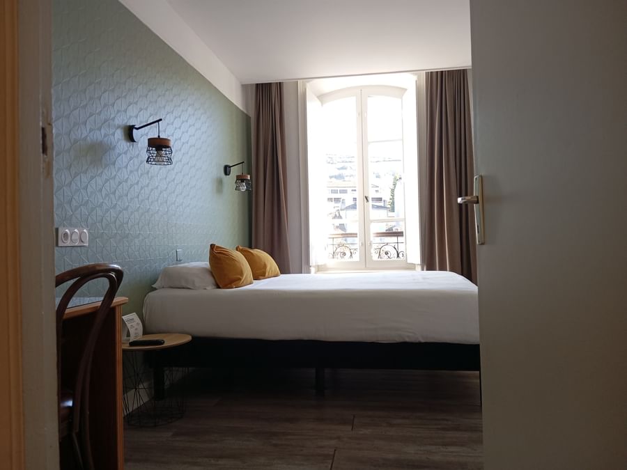 Work desk facing the bed by the window in the Double Superior at The Originals Boutique Grand Hotel Saint-Pierre