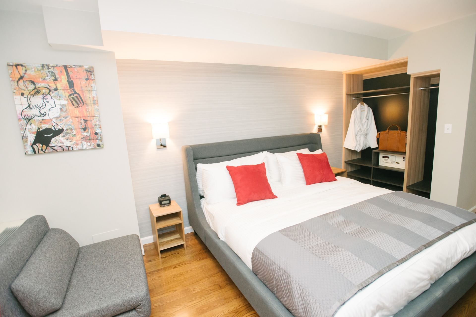 A hotel room with a large bed, sofa, and closet.